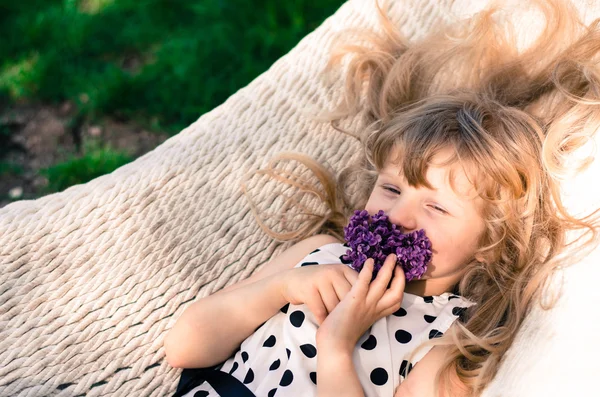 Chica rubia en hamaca con flores — Foto de Stock