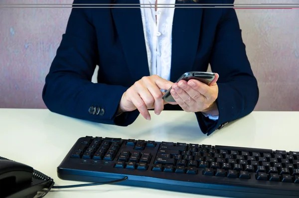 Hand mit Handy und Tastatur — Stockfoto