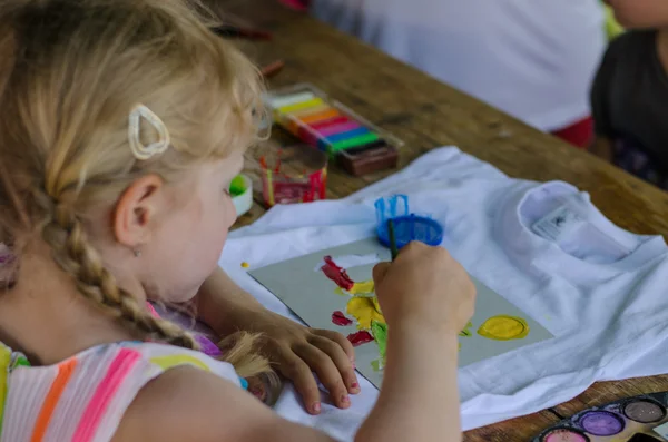 Girl painting into t-shirt — Stock Photo, Image