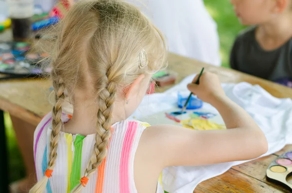 Blond girl with long hair painting back view — Stock Photo, Image