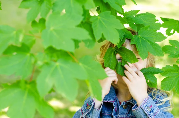 Flicka med gröna blad i ansikte — Stockfoto