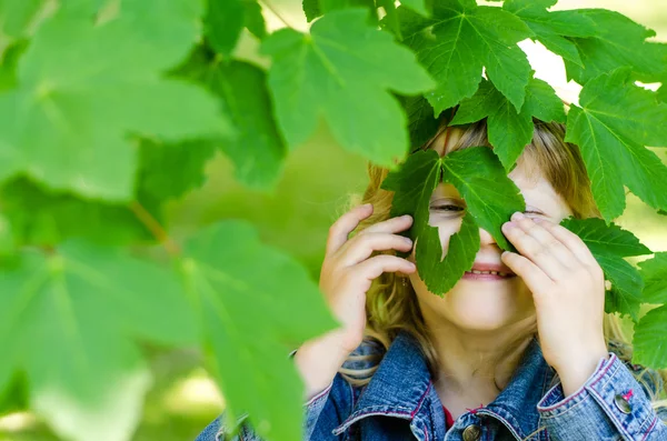 Flicka med gröna blad i ansikte — Stockfoto