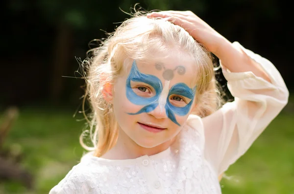 Blond girl with face-painting Royalty Free Stock Images