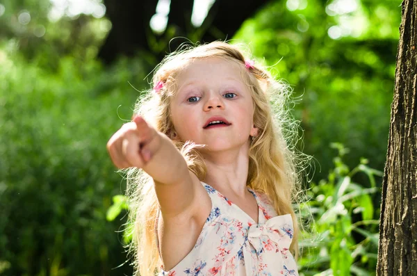 Blond girl showing to something — Stock Photo, Image