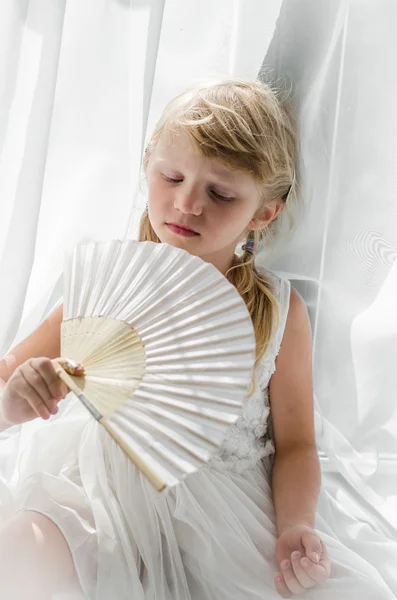 Schattige blonde meisje houden witte ventilator — Stockfoto