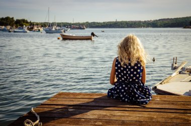 girl sitting in wooden jetty
