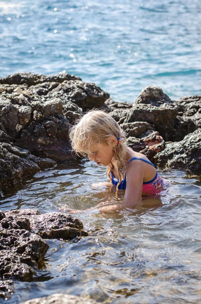 Flicka simning i havet klippan — Stockfoto