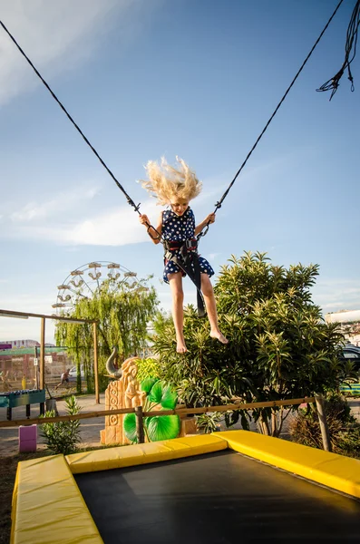 child on bungee attraction