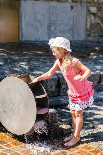 Meisje spelen met water molen attractie — Stockfoto