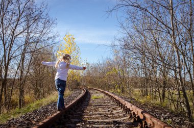 Demiryolu üzerinde yürüyen çocuk