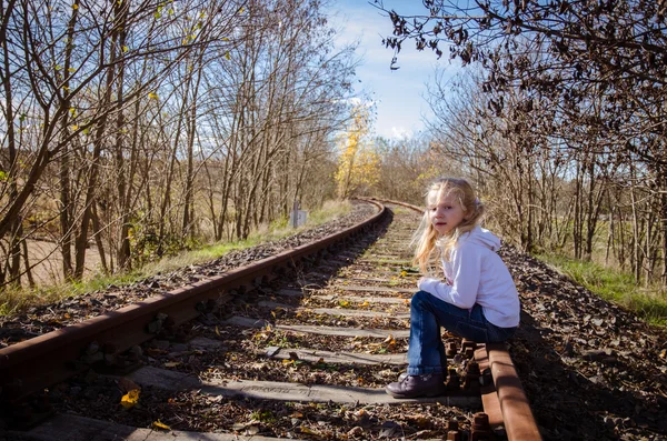 Criança sentada no caminho de ferro — Fotografia de Stock