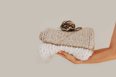 Örgü örüp katlanmış, örgü iğneleri ve iplikle örülmüş bir battaniye.