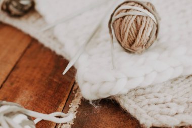 Örgü arka planı - beyaz ve bej el yapımı battaniyeli ahşap tahtalar, iplik ve fotokopi alanı ile örgü iğneleri