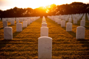 Gün batımında okyanus manzaralı yeşil çimlerin üzerinde beyaz mermer mezarlar olan savaş mezarlığı. Deniz piyadelerinin mezarlığı..