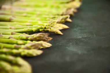 Koyu gri ve beyaz arkaplanda fotokopi alanı ile sıralanmış bir sürü kuşkonmaz. Yeşil kuşkonmaz çerçeve web pankartı.