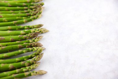 Koyu gri ve beyaz arkaplanda fotokopi alanı ile sıralanmış bir sürü kuşkonmaz. Yeşil kuşkonmaz çerçeve web pankartı.