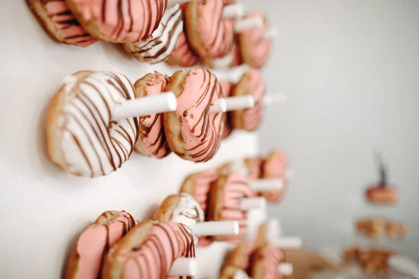 Beyaz duvar tezgahında beyaz ve pembe jöleli çörekler. Taze beyaz ve pembe çöreklerle beyaz ekran.