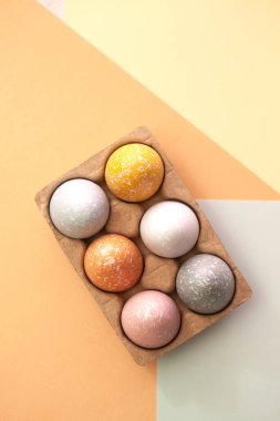 Turuncu, sarı ve gri arka planda beyaz, gri ve sarı yumurtalar. Modern Paskalya konsepti fotokopi alanı içeriyordu. Paskalya tatili.