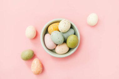 Paskalya yumurtaları açık mavi kasede pembe arka planda..