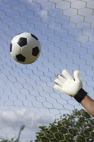 Mãos de goleiro atingindo bola pé — Fotografia de Stock