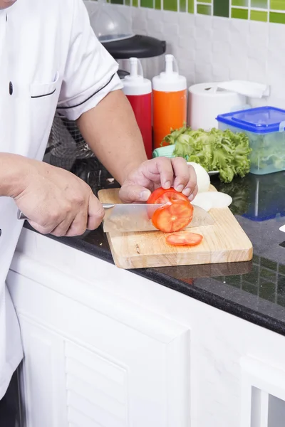 Ręce szefa cięcia pomidorów — Zdjęcie stockowe