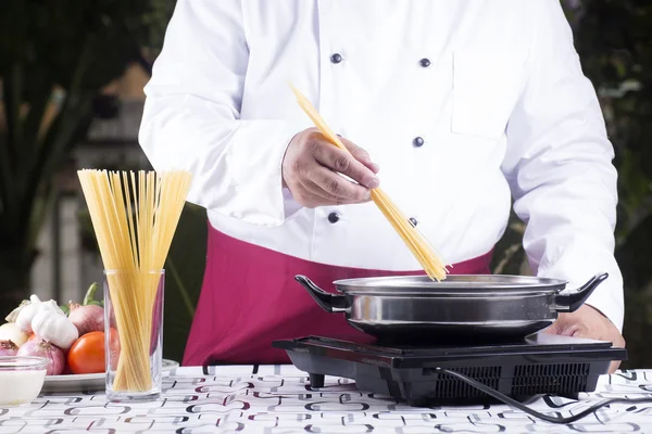 Koch lässt Spaghetti in der Pfanne kochen — Stockfoto