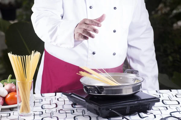 Szef kuchni, wprowadzenie spaghetti gotowany na patelni — Zdjęcie stockowe