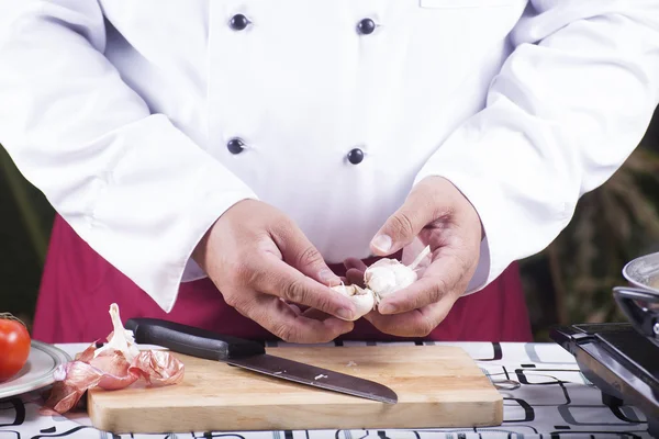 Chef descascando alho com a mão — Fotografia de Stock