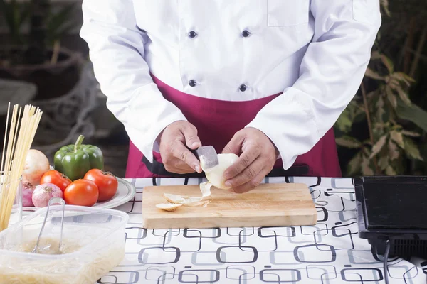 Szef kuchni peeling cebula z nożem — Zdjęcie stockowe