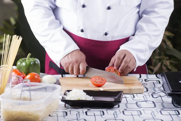 Koch schneidet Tomaten mit Messer vor dem Kochen — Stockfoto