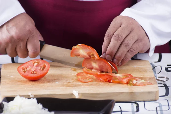 Chef taglio pomodoro con coltello prima della cottura — Foto Stock