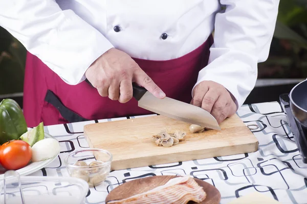 Chef cortando cogumelo com faca antes de cozinhar — Fotografia de Stock