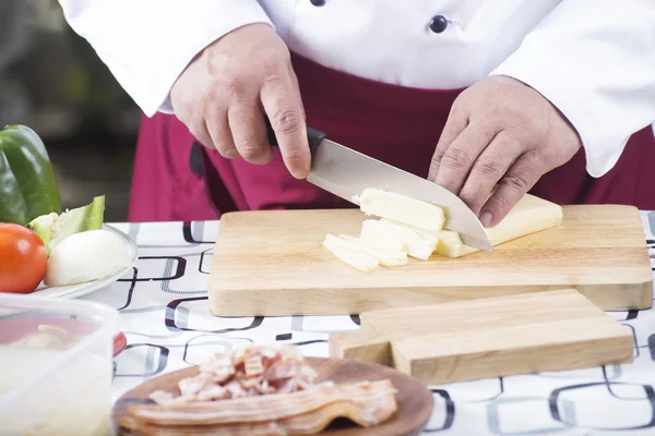 Chef corte de queijo com faca antes de cozinhar — Fotografia de Stock