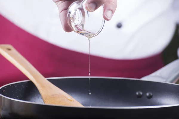 Chef derramando azeite para a panela — Fotografia de Stock