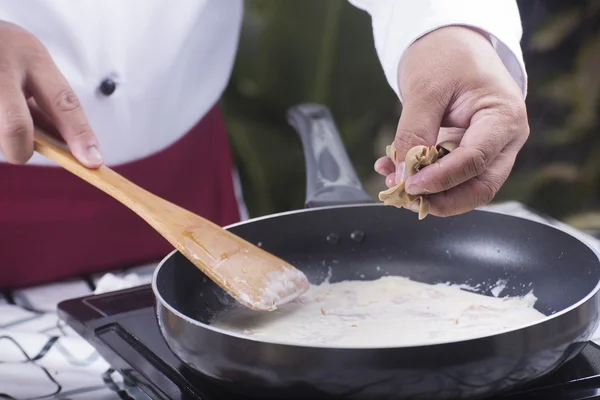 Koch legt Pilz in die Pfanne und kocht Spaghetti Carbonara — Stockfoto
