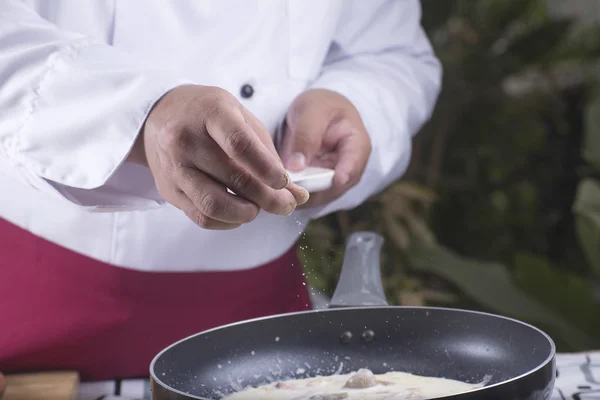 Chef colocando pimenta para a panela de cozinhar espaguete carbonara — Fotografia de Stock