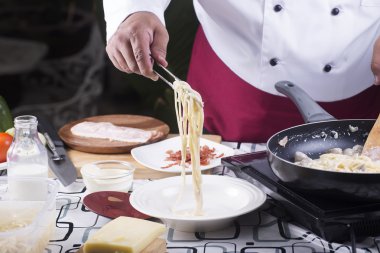 Şef spagetti carbonara plakasına Maşa ile koyarak. 