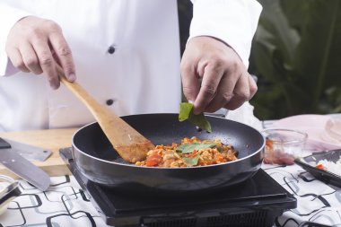 Spagetti tavuk sosu yemek pişirmek için kaydırmak için fesleğen koyarak Şef