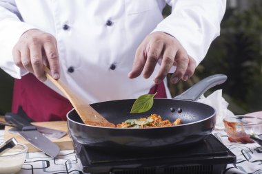 Spagetti tavuk sosu yemek pişirmek için kaydırmak için fesleğen koyarak Şef 