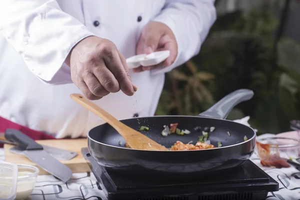 Chef colocando pimenta na panela — Fotografia de Stock