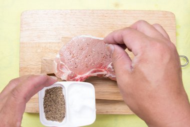 Şef için ham porkchop tuz koyarak 