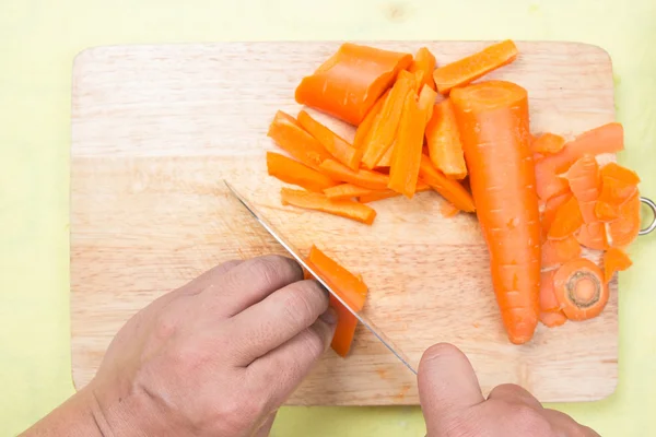 Chef cortando zanahoria en una tabla de madera — Foto de Stock