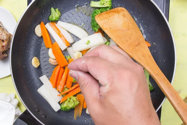 Koch pfeffert Gemüse unter Rühren an — Stockfoto