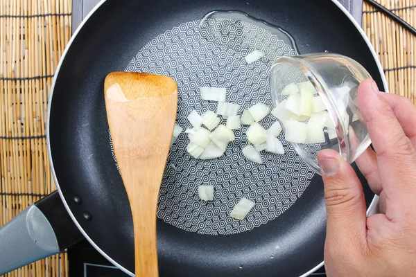 Koch gibt Zwiebel in die Pfanne — Stockfoto