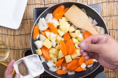 Şef pişirme için pan için tuz ve biber koyarak