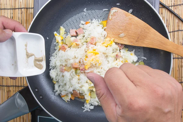 Шеф-повар кладет соль и перец для приготовления жареного риса — стоковое фото