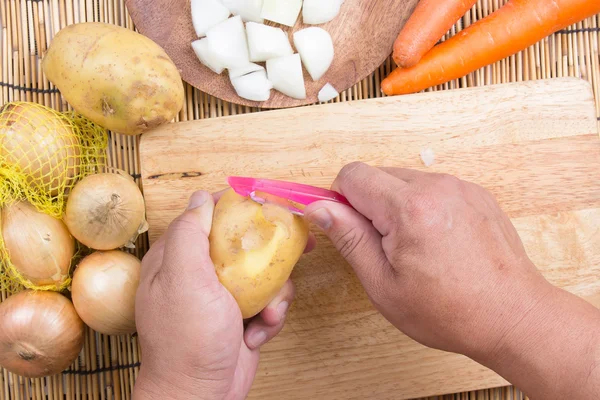 Chef mengupas kentang dengan pisau — Stok Foto
