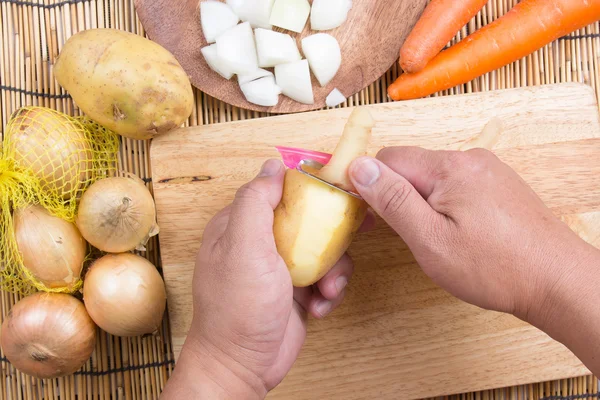 Chef mengupas kentang dengan pisau — Stok Foto