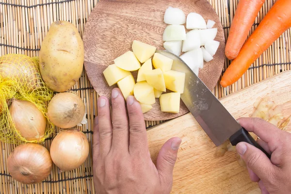 Шеф-повар режет картошку ножом — стоковое фото
