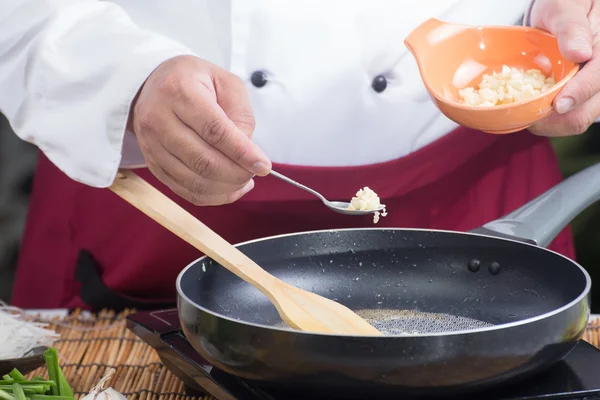 Шеф-повар кладет фарш с чесноком для приготовления тайской кухни — стоковое фото